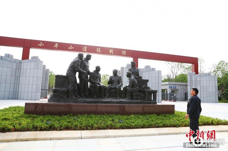 5月18日，参观者站在南昌小平小道陈列馆园区门口观看主题雕塑。