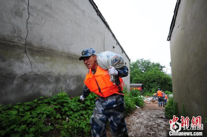 7月14日，中国人民解放军94655部队官兵驰援安徽省芜湖市繁昌县荻港镇庆大圩，开展防汛抢险行动，对堤坝进行进一步加固。　杨大伟 摄