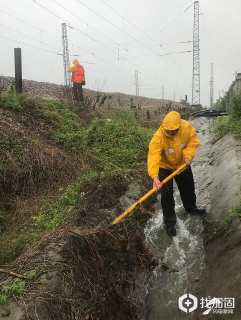 巡检人员雨中疏通排水沟