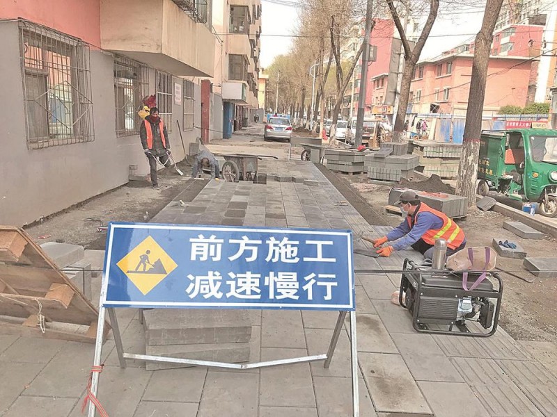 施工人员铺设建北巷人行道地砖
