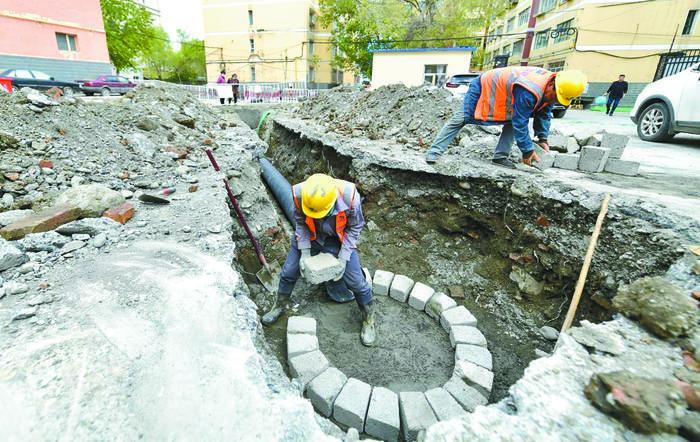 图为施工人员正在该市沙依巴克区一老旧小区建设排污井